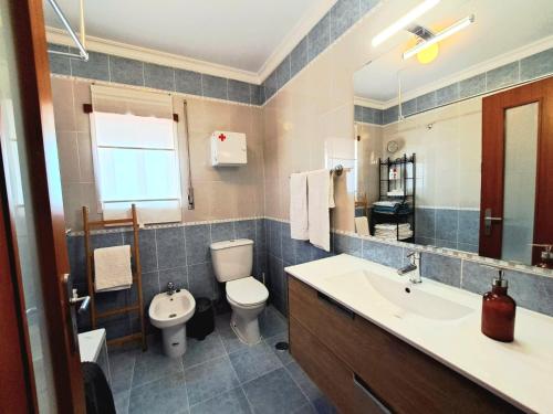 a bathroom with a toilet and a sink and a mirror at MSHomes Corcovada in Albufeira