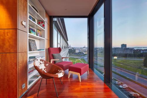 a room with two chairs and a large window at Hilton Reykjavik Nordica in Reykjavík