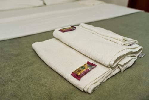 dwa białe ręczniki siedzące na łóżku w obiekcie RECANTO PRAIA SUITES w mieście Arraial do Cabo