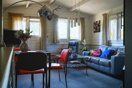 een woonkamer met een bank en een tafel bij Chalet op een rustig park in de natuur in Putten