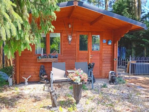 een hut met een tafel en stoelen ervoor bij Chalet op een rustig park in de natuur in Putten