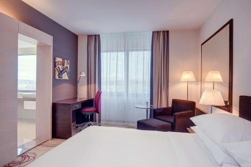 um quarto de hotel com uma cama e uma cadeira em DoubleTree By Hilton Košice em Košice