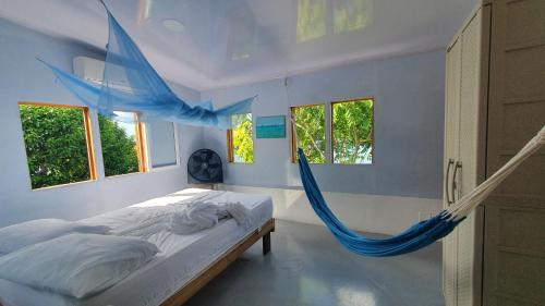 - une chambre avec un lit et un hamac dans l'établissement Bellavista - Blue Lizard Studio, à Île de la Providence