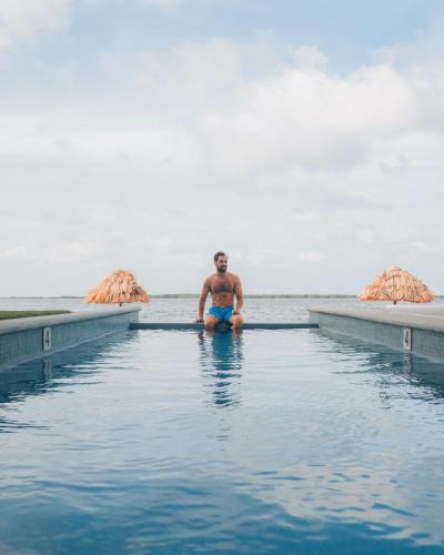サン・ペドロにあるPlaya De Sala Boutique Hotelの海に座る男