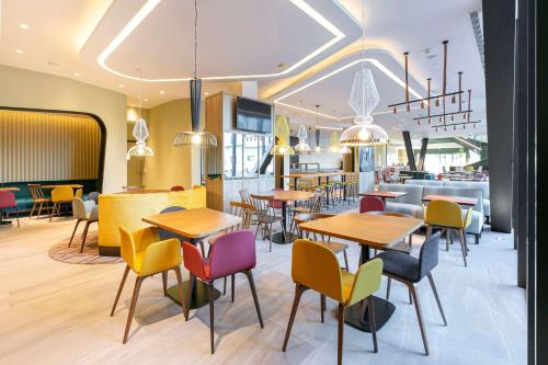 a restaurant with tables and chairs and a bar at Hampton By Hilton Alcobendas Madrid in Alcobendas
