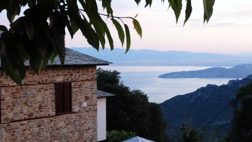 a building with a view of a lake and mountains at Iliopetra Suites in Agios Lavredios