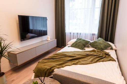 a bedroom with a bed and a flat screen tv at Juozapaviciaus apartment in Kaunas