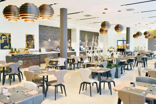 un restaurante con mesas y sillas y un bar en Hilton Garden Inn Milan North, en Milán