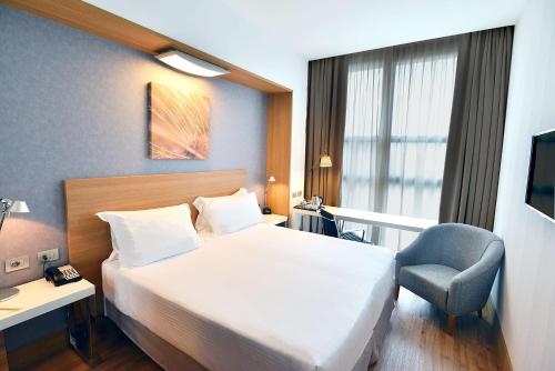 a hotel room with a bed and a chair at Hilton Garden Inn Milan North in Milan