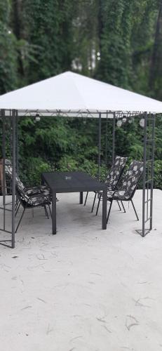 VinciにあるGuesthouse Silvaの白い天蓋の下の黒いテーブルと椅子