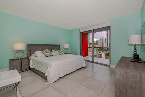 una camera con un letto e una grande finestra di Beachwalk condo resort a Hallandale Beach
