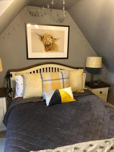 a bedroom with a bed with a picture of a dog on the wall at Hetherington House in Maybole