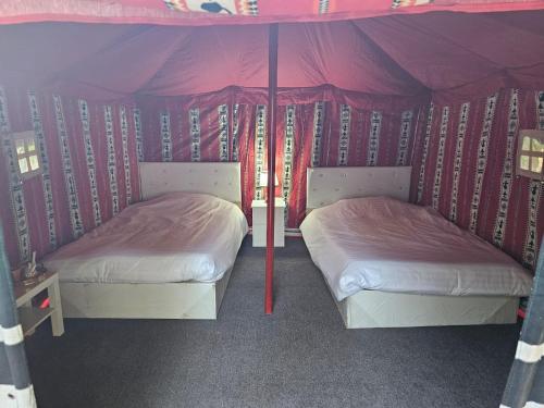 Duas camas num quarto com uma tenda em Mango Farm Camp em Al-Disah