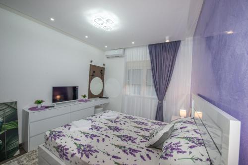 a bedroom with a bed and a mirror and a tv at Apartment Lara in Ulcinj