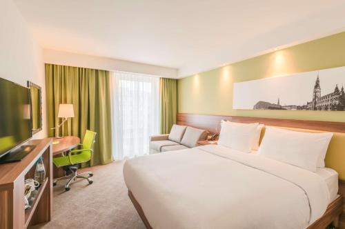 a hotel room with a large bed and a desk at Hampton By Hilton Munich City West in Munich