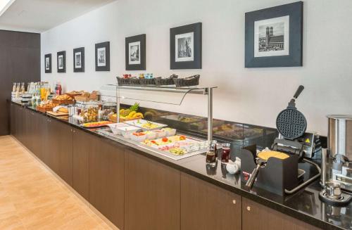 una línea de buffet con mucha comida en Hilton Garden Inn Munich City West, en Múnich