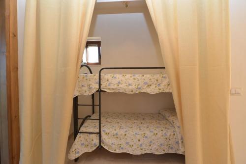 a small room with a bunk bed with curtains at Masseria Pentima Vetrana Resort in Alberobello