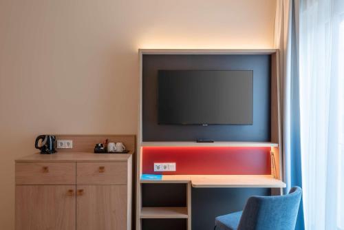 a room with a flat screen tv in a room at Hampton By Hilton Munich City North in Munich
