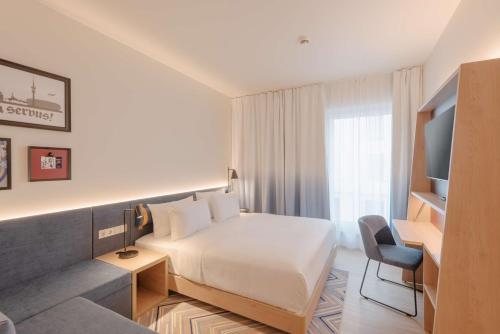 a hotel room with a bed and a chair at Hampton By Hilton Munich City North in Munich