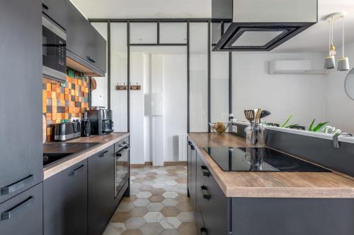 a kitchen with stainless steel appliances and wooden counter tops at Beautiful 2-room apartment with a view in Lyon - Welkeys in Lyon