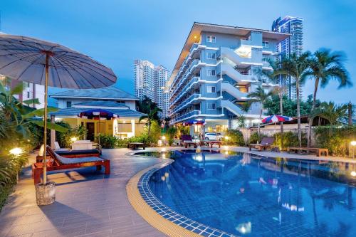 a hotel with a swimming pool in front of a building at Tycoon place garden in Pattaya South