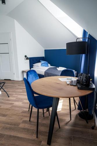 a room with a table and chairs and a bed at La Familia TYBURA in Uniejow