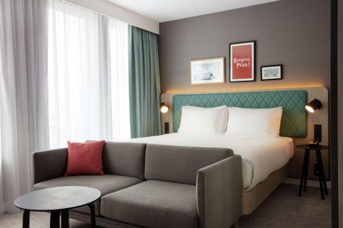 um quarto de hotel com uma cama e um sofá em Hilton Garden Inn Paris Orly Airport em Rungis