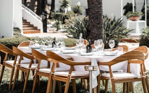 a table with glasses and wine bottles on it at Hilton Mallorca Galatzo in Paguera