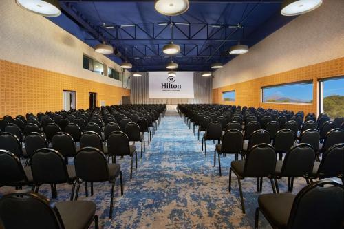 an empty room with chairs and a stage in the background at Hilton Mallorca Galatzo in Paguera