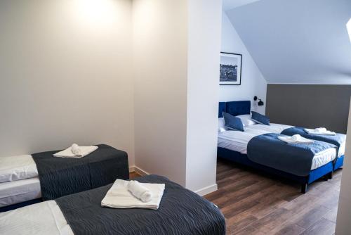 a hotel room with two beds with towels on them at La Familia TYBURA in Uniejow