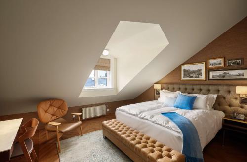 ein Schlafzimmer mit einem großen Bett mit blauen Kissen in der Unterkunft Reykjavik Konsulat Hotel, Curio Collection By Hilton in Reykjavík