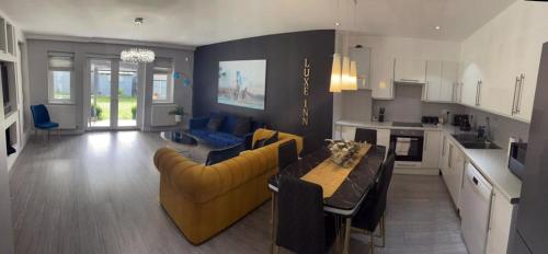 a kitchen and living room with a couch and a table at Luxury, 4 Bedroom House, FREE Parking, Borehamwood in Borehamwood