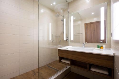 La salle de bains est pourvue d'un lavabo et d'un miroir. dans l'établissement Hilton Garden Inn Orenburg, à Orenbourg