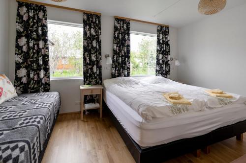 una camera con due letti e una finestra di Túnfífill Guesthouse - free hot tub and sauna, cozy and quiet a Hvammstangi