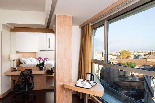 ローマにあるホテル クラリッジのベッドと窓の景色を望むホテルルーム