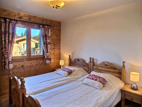 une chambre avec deux lits jumeaux et une fenêtre dans l'établissement Lucada Les Carroz, aux Carroz d'Arâches