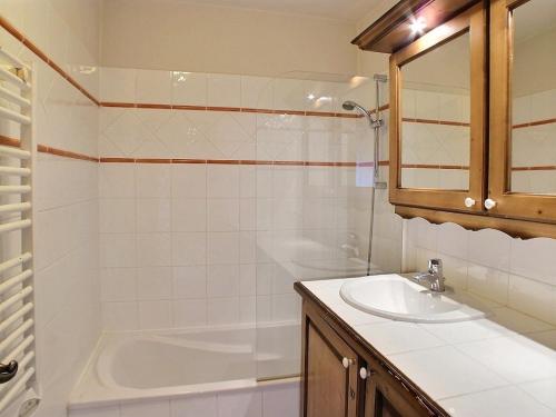 une salle de bain avec un lavabo et une baignoire dans l'établissement Lucada Les Carroz, aux Carroz d'Arâches