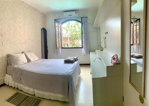 um quarto com uma cama, um lavatório e uma janela em Retiro Luxuoso:Casa Espaçosa com Piscina Privativa em Campos dos Goytacazes