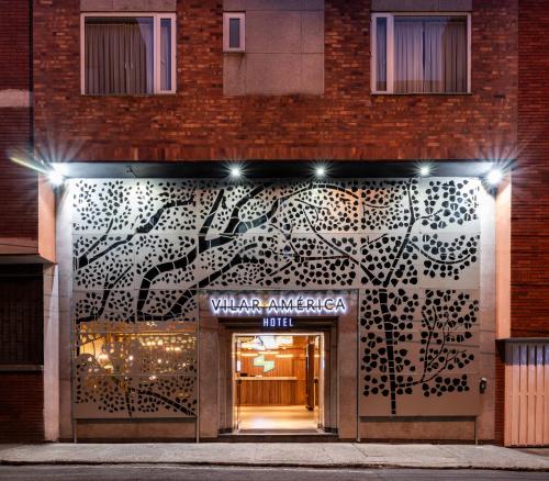a building with a door with a tree painted on it at Suites by Vilar América in Bogotá