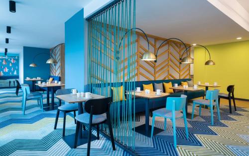 a restaurant with tables and chairs in a room at Hampton By Hilton Moscow Rogozhsky Val in Moscow
