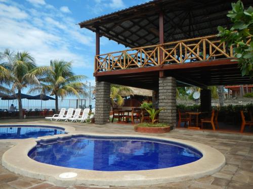 a resort with a swimming pool and a pavilion at Punta Roca Surf Resort in La Libertad