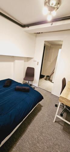 1 dormitorio con 1 cama y 2 sillas en una habitación en New York basement apartment en Copenhague