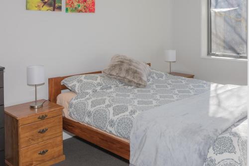 a bedroom with a bed and a nightstand with two lamps at Colcord Hideaway in Methven