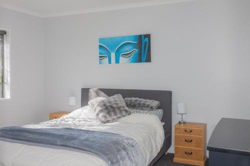 1 dormitorio con 1 cama con una pintura azul en la pared en Colcord Hideaway en Methven