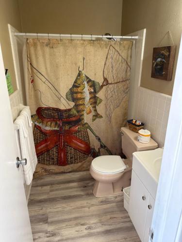 La salle de bains est pourvue de toilettes et d'un rideau de douche. dans l'établissement Sportsman's Lodge, à Fairfield Bay
