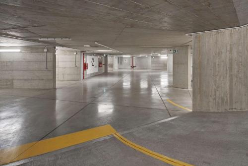 an empty parking garage with a yellow line on the floor at DoubleTree By Hilton Trieste in Trieste