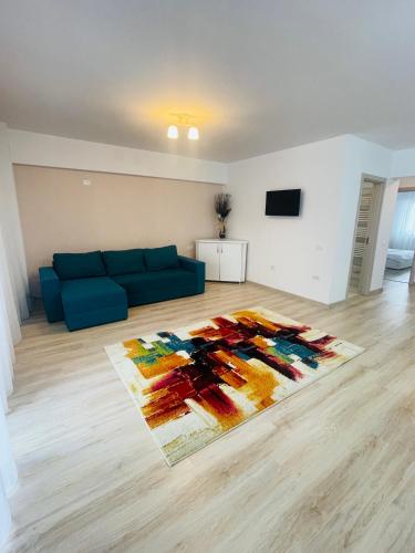 sala de estar con sofá azul y alfombra en Apartament YRA Rm.Valcea en Râmnicu Vâlcea