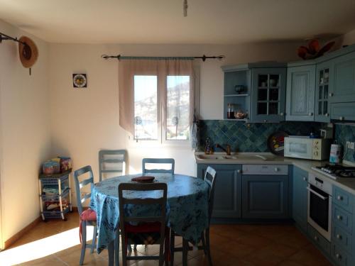 a kitchen with a table and chairs and a window at La Giraglia in Centuri