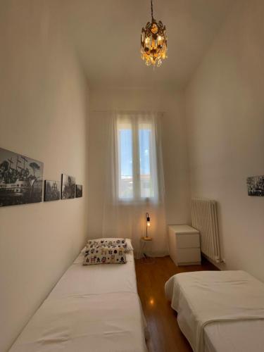 a bedroom with two beds and a chandelier at Casa Linda in Fano