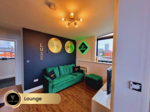 a living room with a green couch and a television at Bull's Ring 3Bed Penthouse City Centre in Birmingham